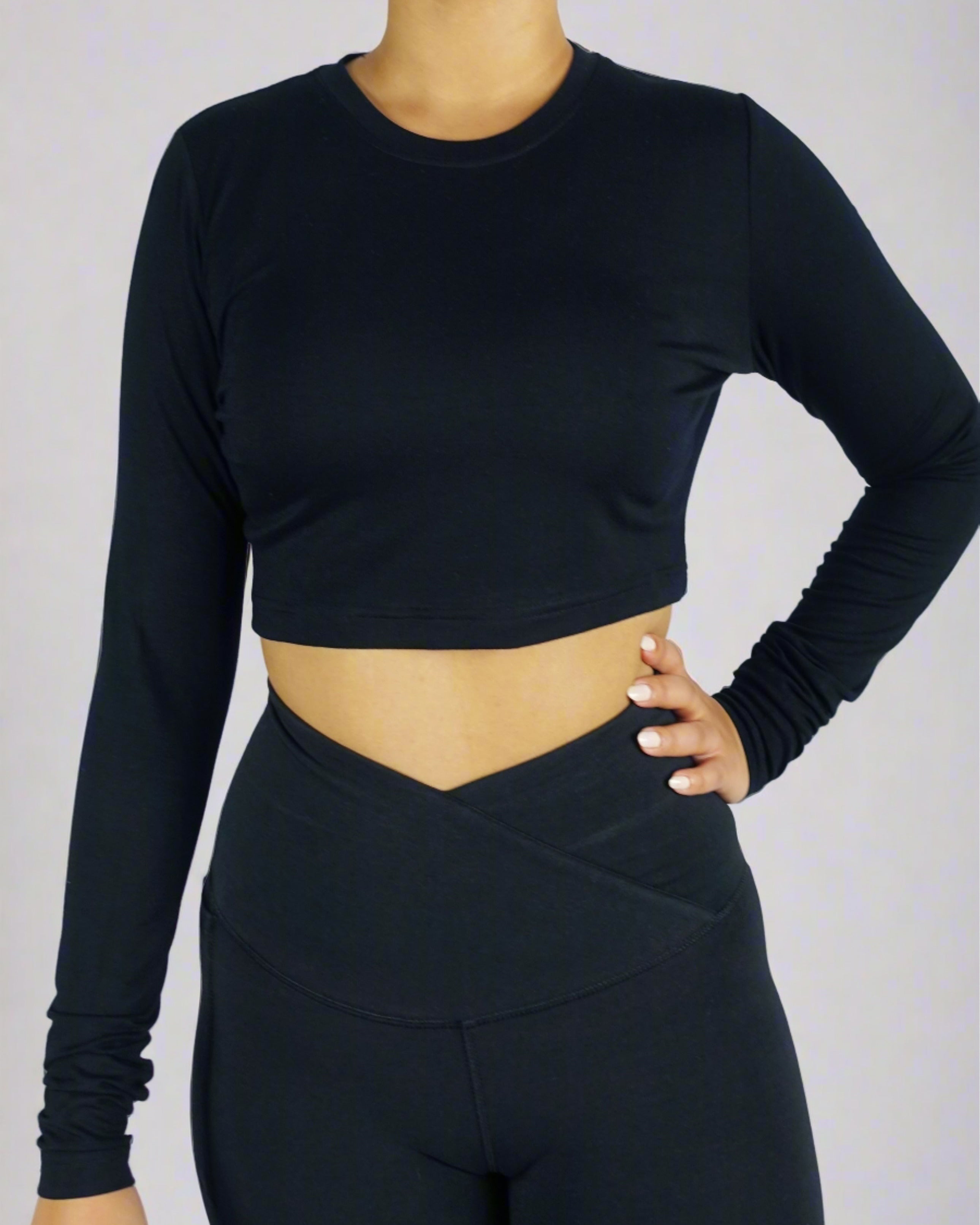 Front view of a woman wearing a black long sleeve crop tee