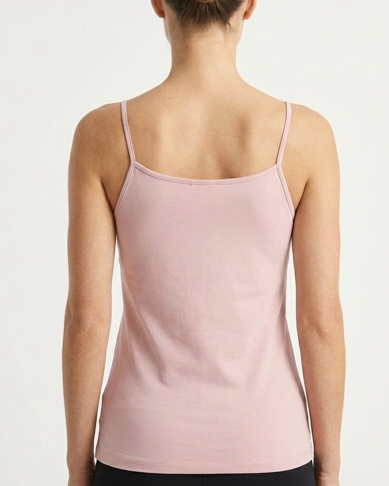 Woman wearing a light pink tank top Bamboo Camisole Singlet soft and breathable hypoallergenic moisture wicking in Blush Pink against a plain background