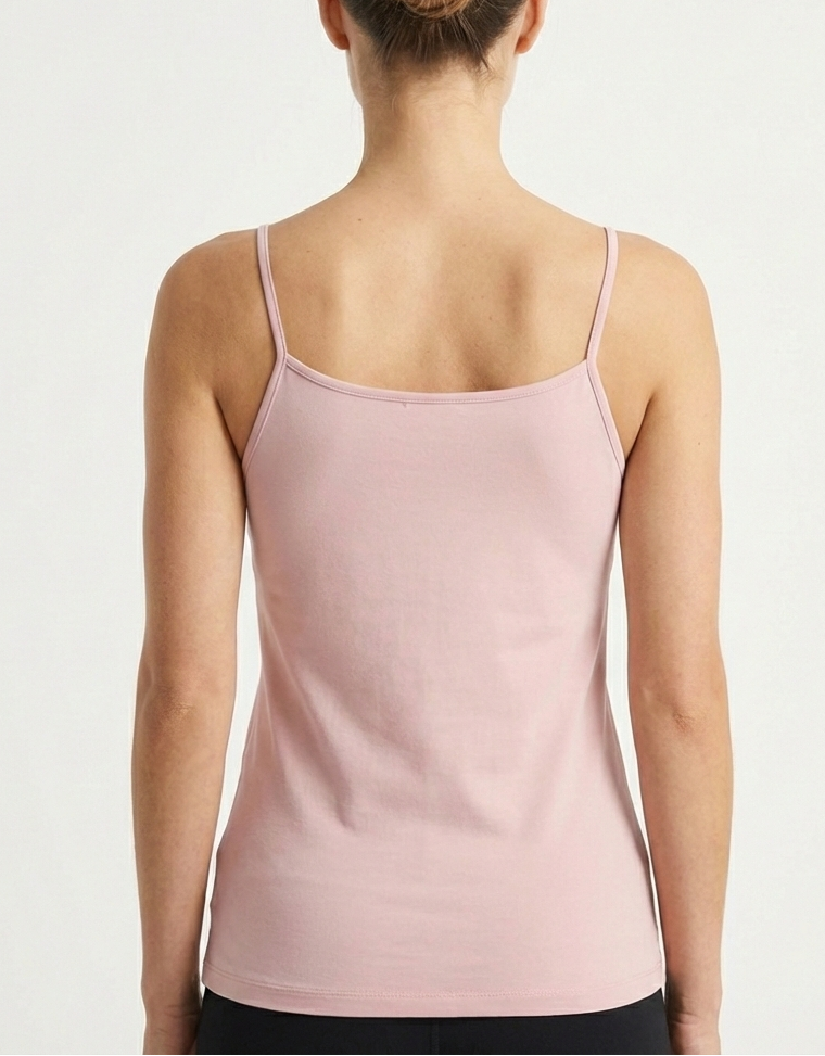 Woman wearing a light pink tank top Bamboo Camisole Singlet soft and breathable hypoallergenic moisture wicking in Blush Pink against a plain background