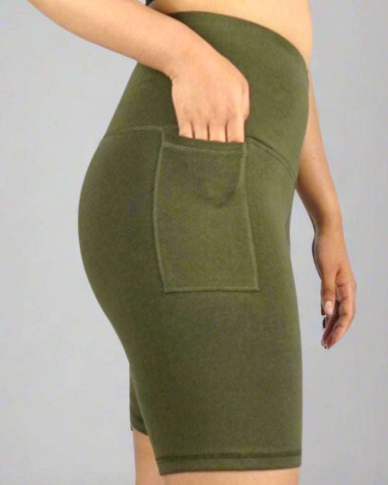 Khaki Olive green bike shorts with phone pocket on a person against a gray background