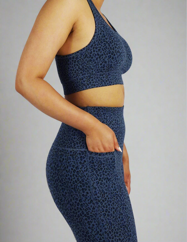 Side view of model wearing blue leopard print sports bra