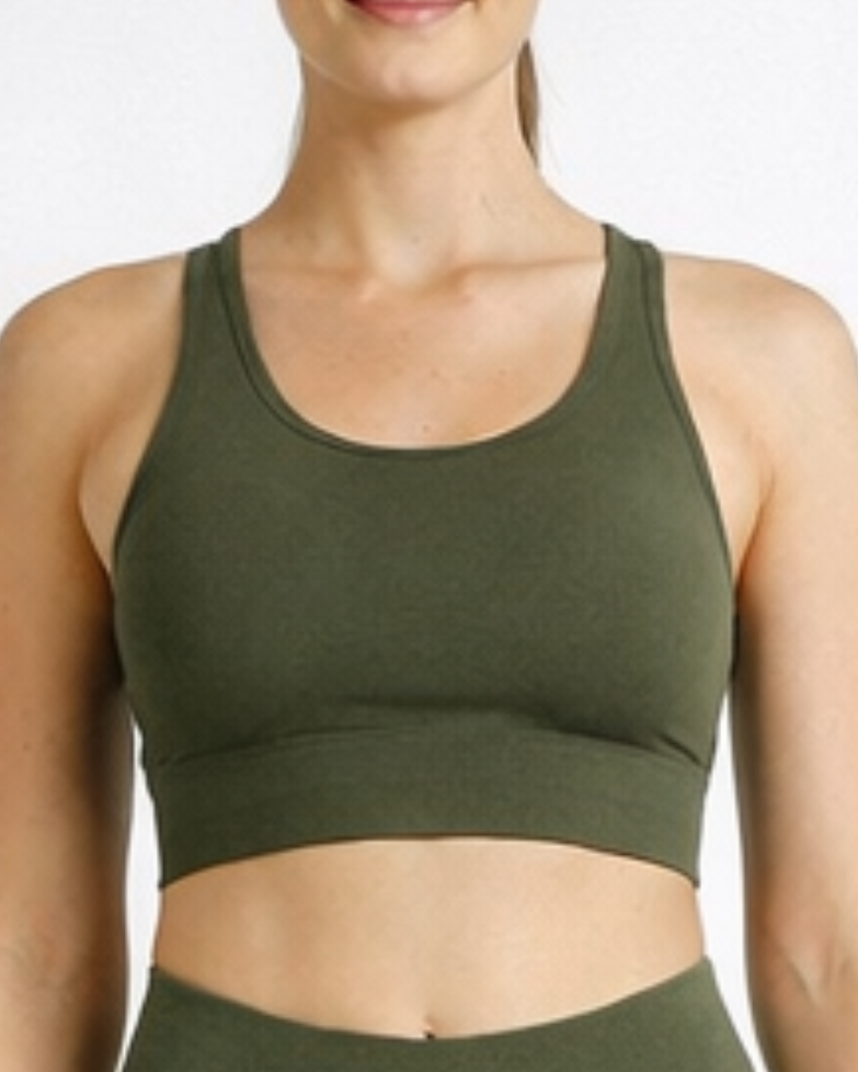 Woman wearing an olive green athletic outfit on a white background