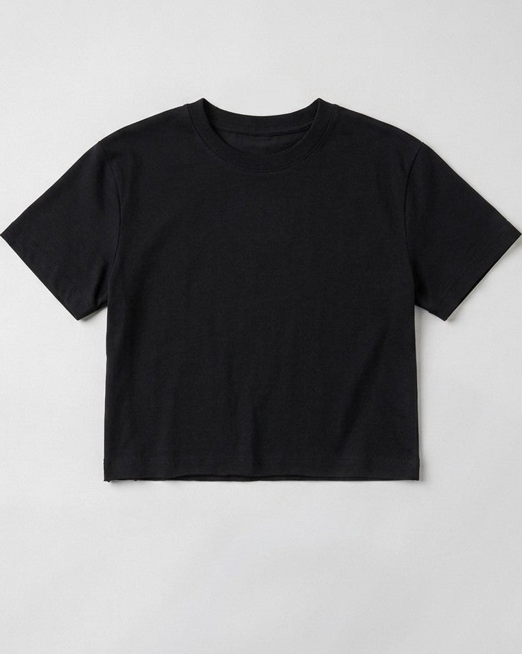 Flat lay product shot of a women's Black boxy cropped t-shirt featuring a relaxed crew neck cut and short drop sleeves on a plain light grey background