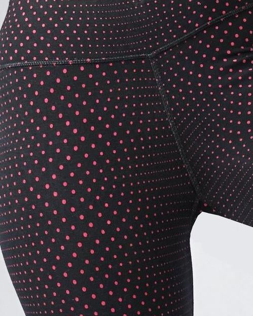 Close up view of red polka dot black crop leggings