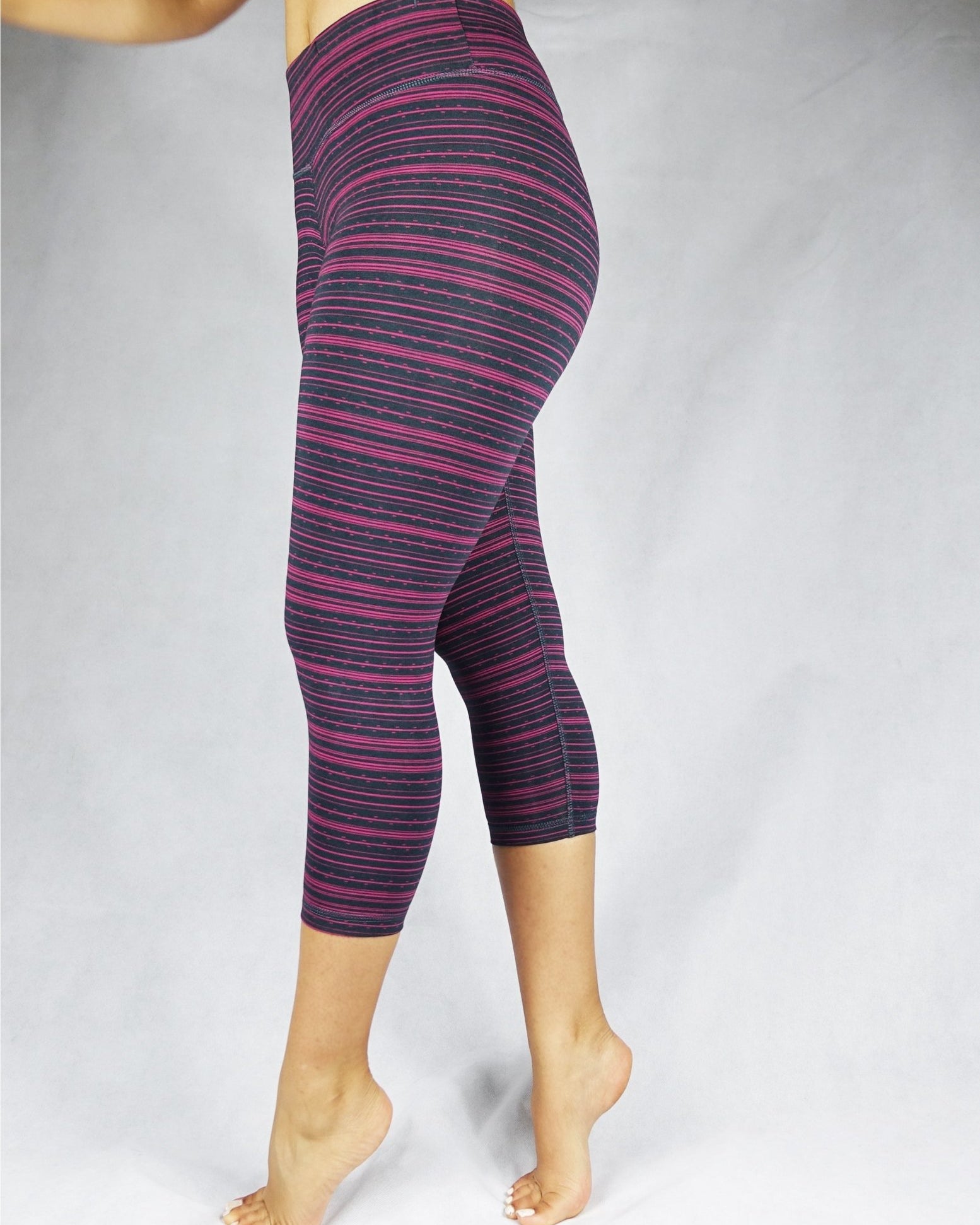 Side view of pink stripe on black crop leggings, activewear
