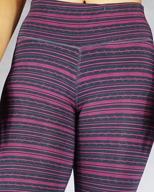 Close up front view of pink stripe on black crop leggings