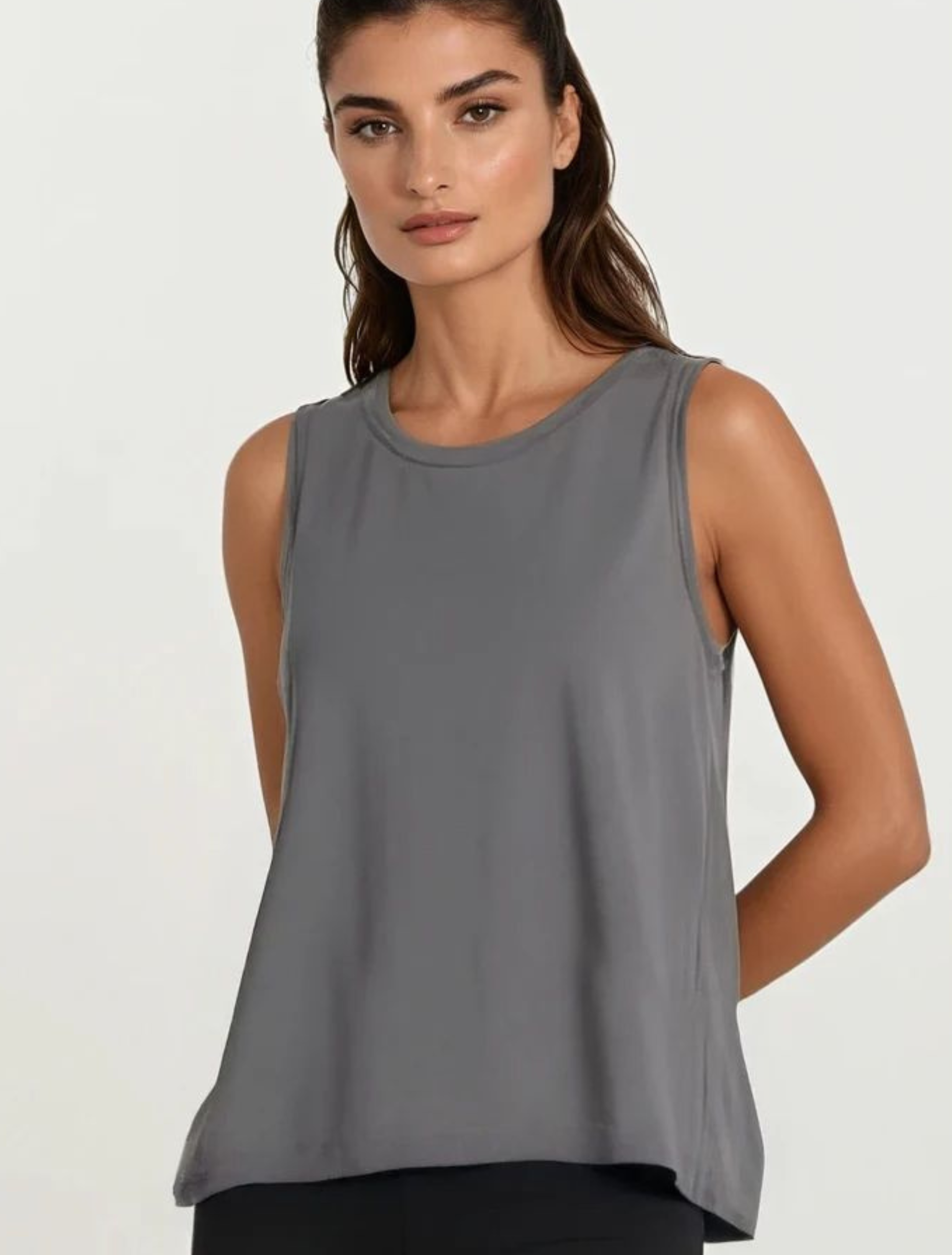 Woman wearing a gray sleeveless top on a white background