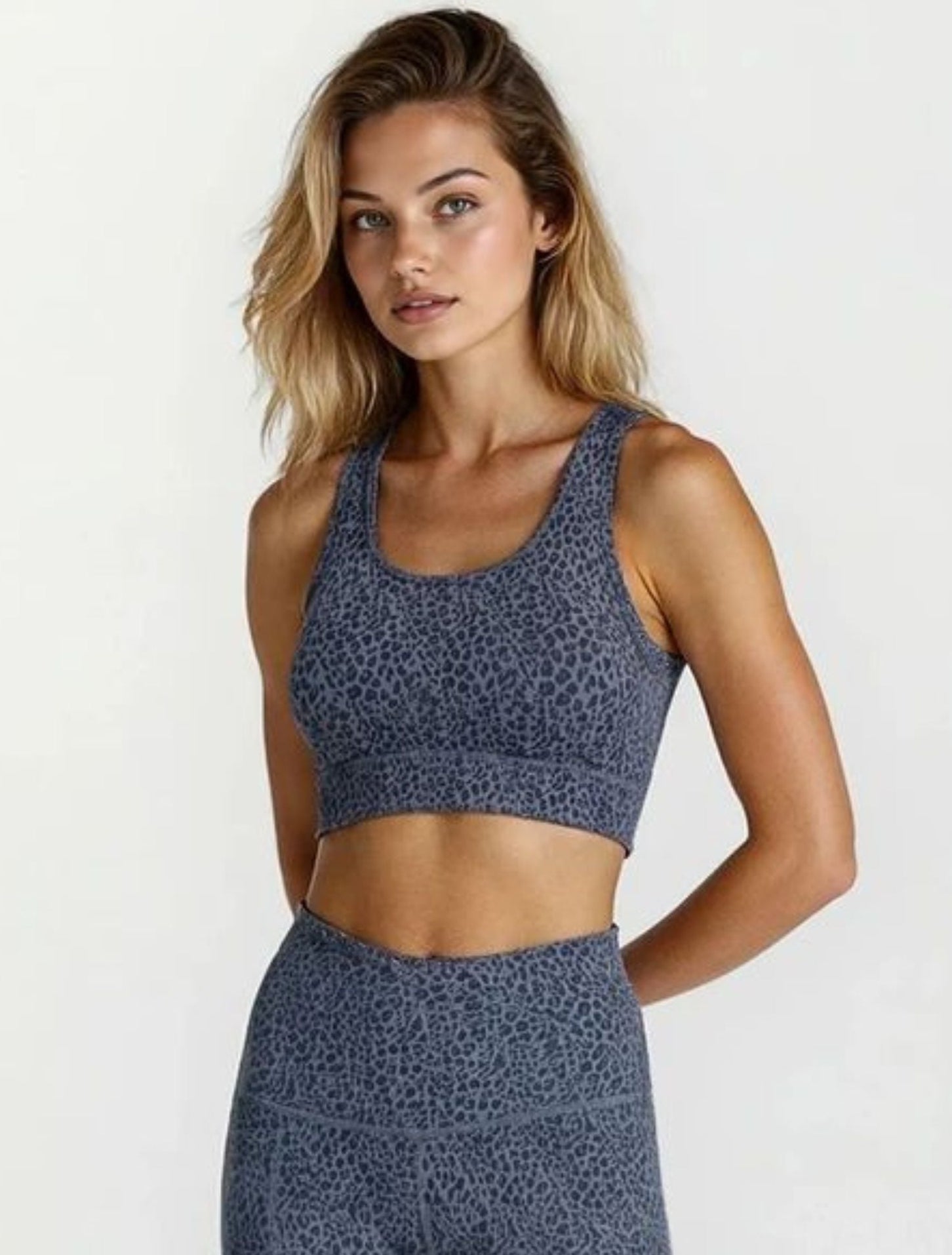 Woman wearing a blue patterned sports bra and leggings Teal Blue Paw Print Bamboo Swift Tights Super Soft Breathable Hypoallergenic_ Active by GS on a white background