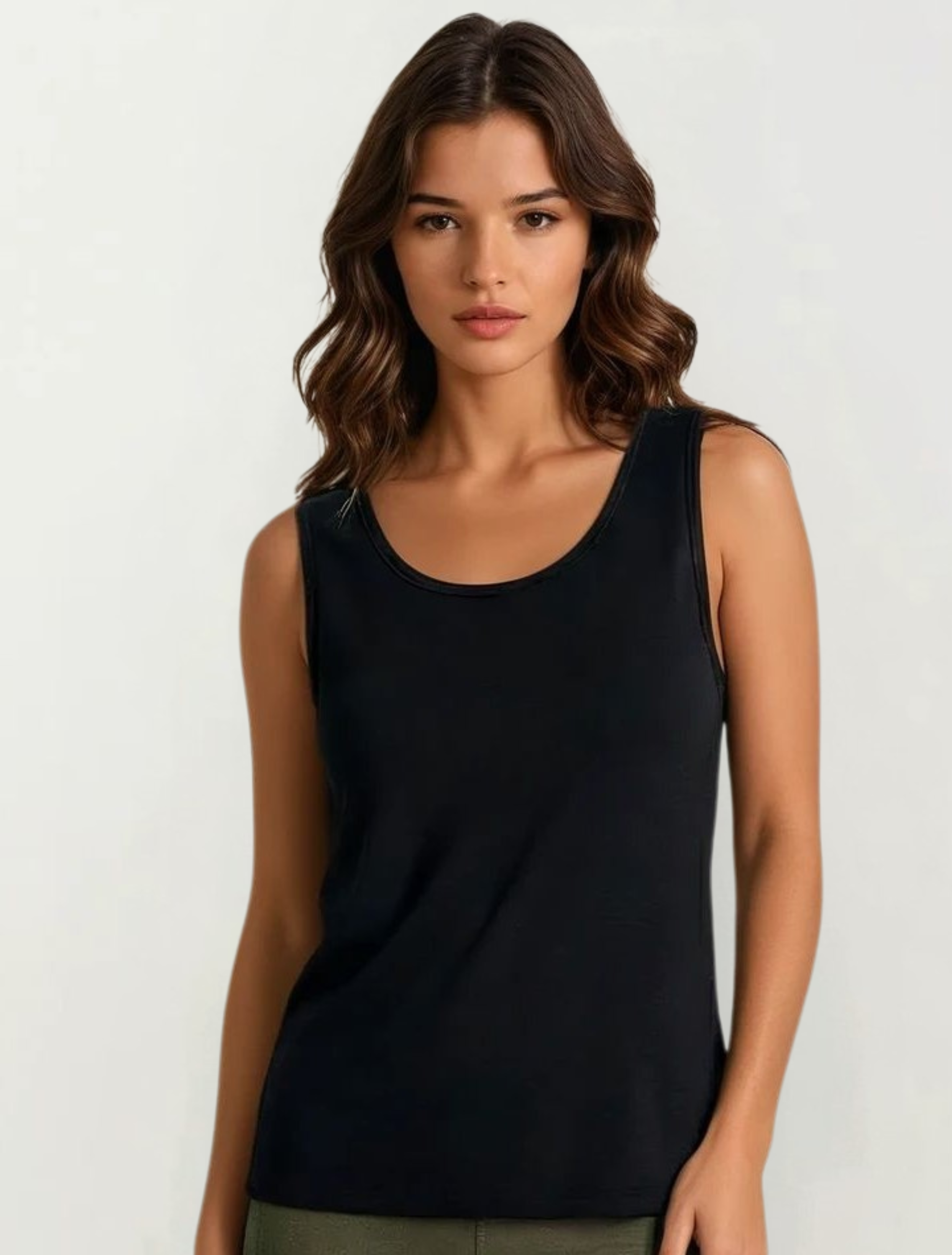 Woman wearing a black tank top against a white background