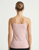 Woman wearing a light pink tank top Bamboo Camisole Singlet soft and breathable hypoallergenic moisture wicking in Blush Pink against a plain background