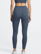 Back side of the person wearing blue patterned leggings leopard print Bamboo Swift Cross Waist Legging Super Soft Breathable Hypoallergenic_ Active by GS on a white background