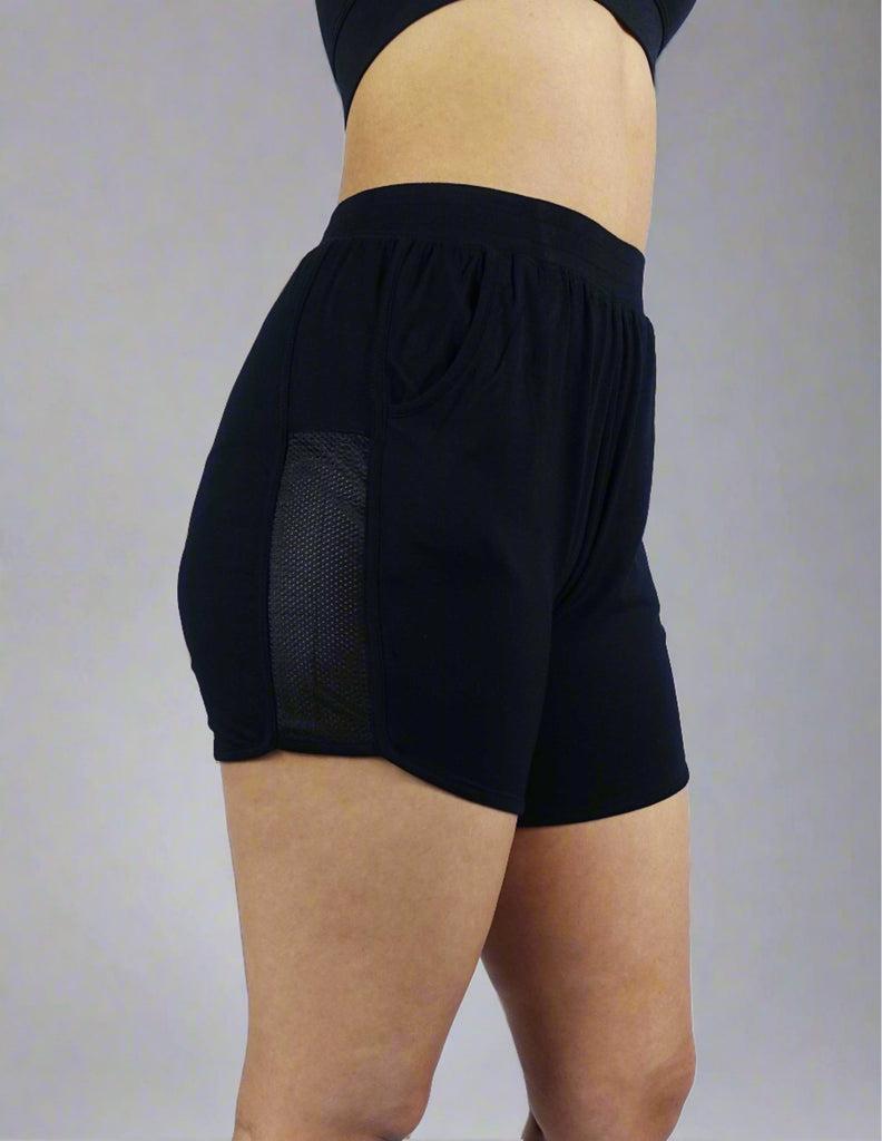 Side view of black women's mid length shorts with mesh