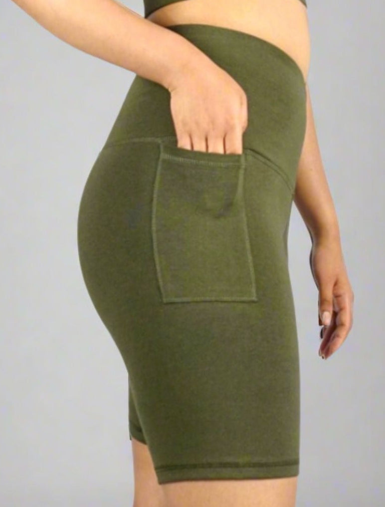 Khaki Olive green bike shorts with phone pocket on a person against a gray background