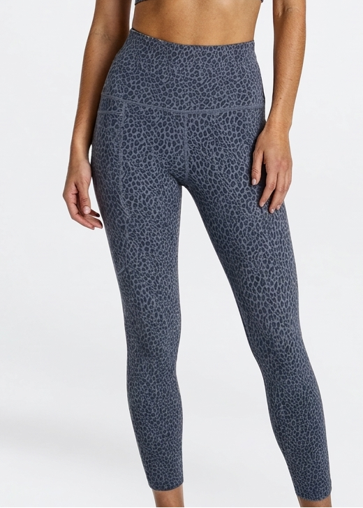Woman wearing a leopard patterned animal print phone pocket leggings in super soft bamboo on a white background
