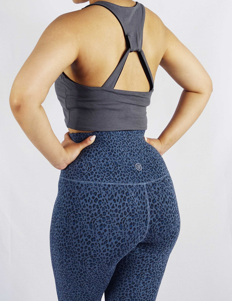 Back view of model wearing grey side of black and grey reversible crop top