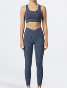 Woman wearing a blue patterned athletic outfit of Teal Blue Paw Print Bamboo Swift Cross Leg Legging Super Soft Breathable Hypoallergenic by Active by GS on a white background