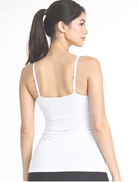 Woman wearing a white tank top two-way bamboo organic cotton camisole V and round neck reversible design on a plain background