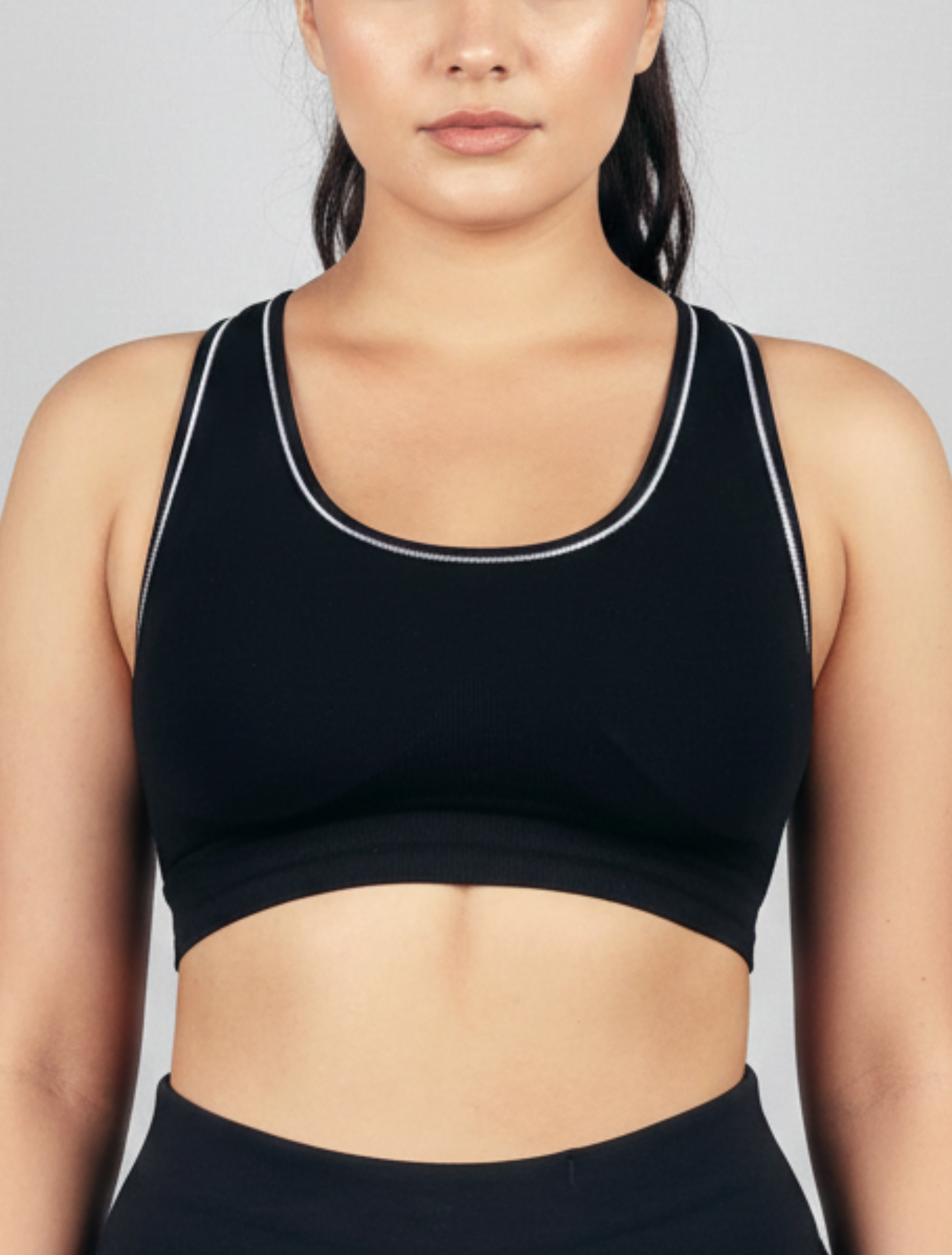 Black sports bra with silver trim Womens Black ribbed seamless-wirefree-bra-Bamboo super soft hypoallergenic breathable Tank orn by a person on a plain background