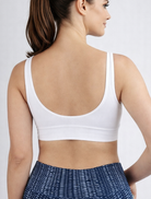 Woman wearing a white seamless bra in bamboo super soft fabric breathable and hypoallergenic on a light gray background
