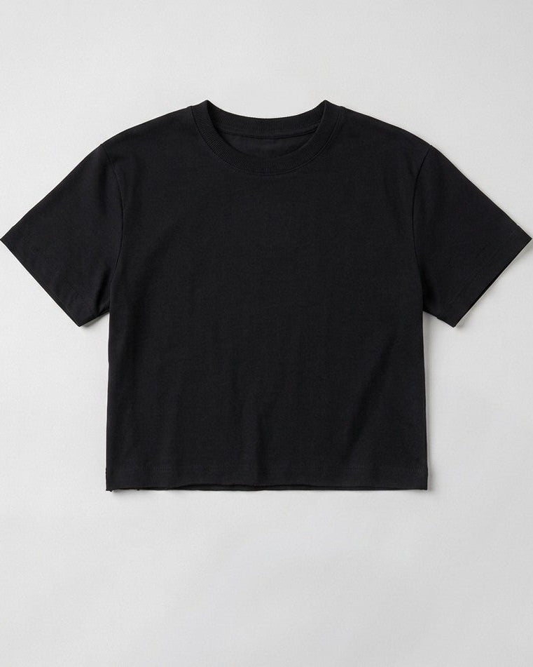 Flat lay product shot of a women's Black boxy cropped t-shirt featuring a relaxed crew neck cut and short drop sleeves on a plain light grey background