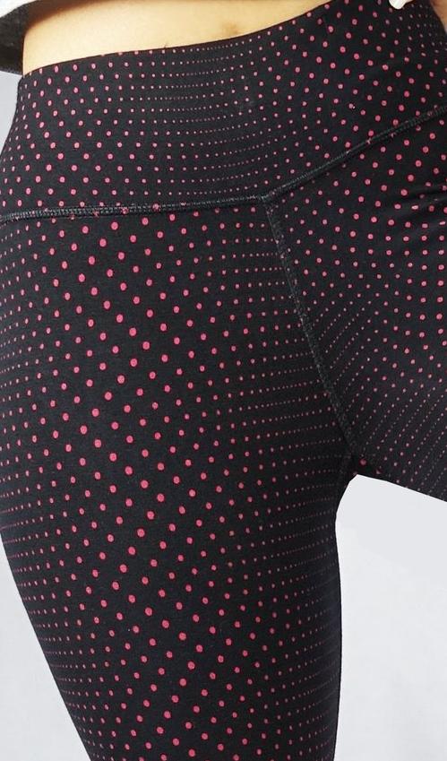 Close up view of red polka dot black crop leggings
