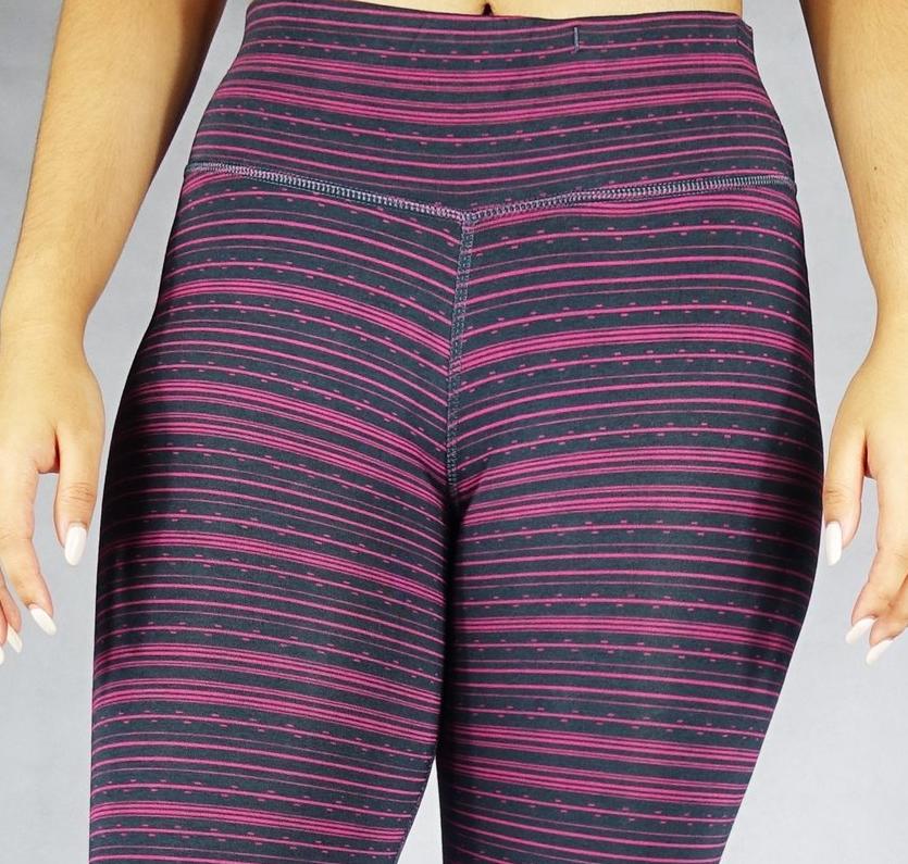 Close up front view of pink stripe on black crop leggings