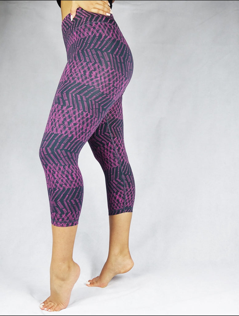Side view of model wearing plum coloured patterned crop leggings